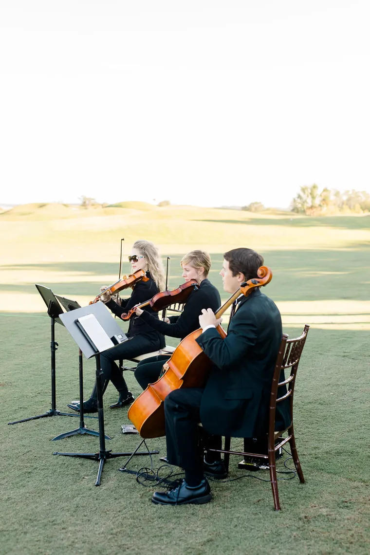 String trio performing at a golf course event