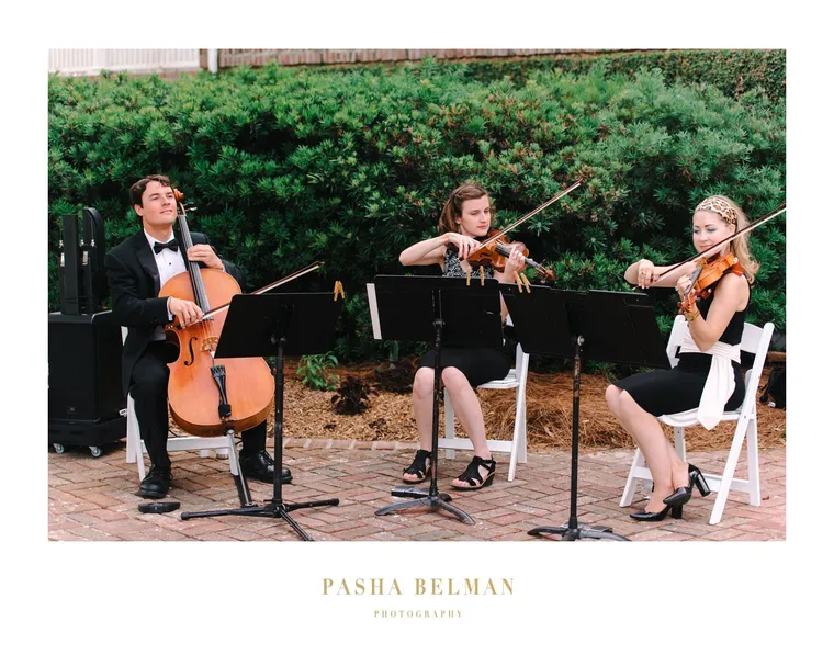 String trio performing at a garden wedding